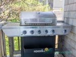 A gas grill with propane and BBQ tools is awaiting.